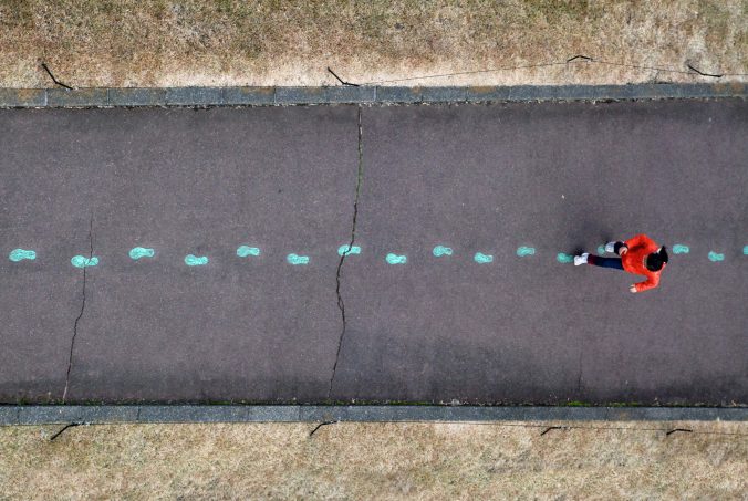 A top down photo of a person walking along an empty road